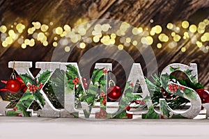 decoupage decorated XMAS letters on wooden background with bokeh effect