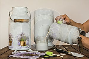Decoupage - hands painting milk churns with a sponge