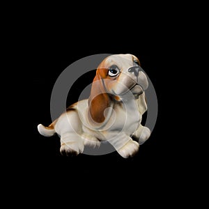 Antique figurine of a dog on a black isolated background. puppy toy.