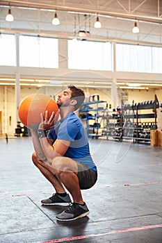 Dedicate yourself to becoming your best. Full length shot of a handsome young man working out with a medicine ball in