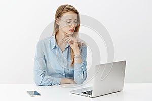 Dedicated female worker staying in office late as finishing business plan, sending email to customer, sitting near