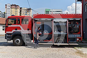 A dedicated firefighter preparing a modern firetruck for deployment to hazardous fire-stricken areas, demonstrating