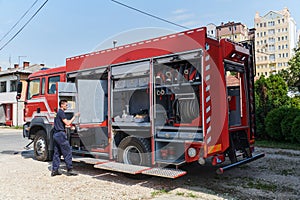 A dedicated firefighter preparing a modern firetruck for deployment to hazardous fire-stricken areas, demonstrating