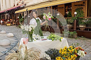 Dedicated Florist Preparing Bouquets at Street Stall. Florist at work. Workplace. Small business