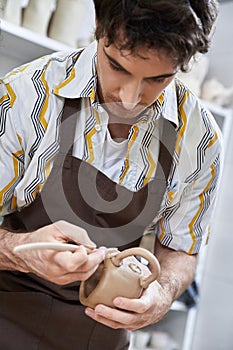 Dedicated man making pottery in studio.