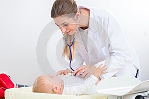 Dedicated pediatrician using the stethoscope during the check-up photo