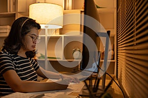 Dedicated Young Woman Studying Online Late at Night in Her Home Office