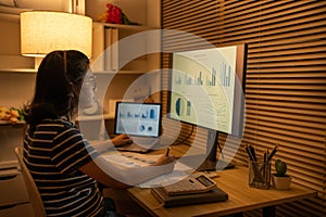 Dedicated Young Woman Studying Online Late at Night in Her Home Office