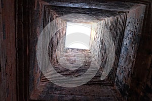 Deep ancient well. Masonry. Light at the end of the tunnel. Background