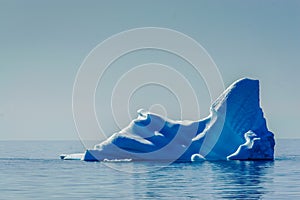 Deep blue Iceberg floats in the Arctic sae, melting