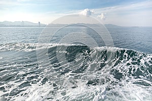 Deep blue ocean wave with mountain and sky