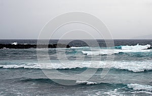 Deep blue ocean waves in a winter seascape with surf breaking