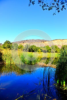 Deep blue reflective lake waters with mountains