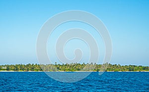 A deep blue sea with island in distance with medium water wave ripple