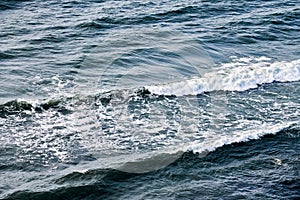 Deep blue sea waters splashing with foamy waves, dark blue wavy ocean water surface, stormy sea