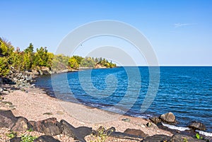 Deep blue water, sand beach and clear sky among bush natures