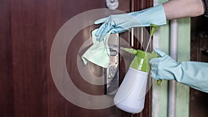 Deep cleaning for the prevention of viral diseases. Disinfection a door handle at home with an alcohol disinfectant spray