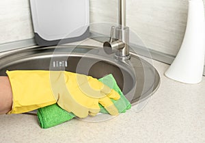 Deep Cleaning service. woman gloves hands cleaning kitchen sink. Surface sanitizing. Home cleaning spraying antibacterial spray