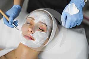 Deep cleansing at beauty saloon. High angle closeup portrait of relaxed beautiful caucasian woman during facial