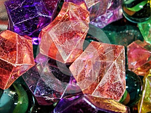 Deep-colored marble-like stones and colorful glass orbs, close-up background with selective focus