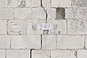 Deep crack in a natural old stone wall cause due structural subsidence of the subsoil photo