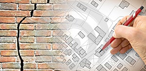 Deep crack in an old brick wall with - concept image with a city map and engineer who is drawing