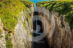 The deep crevice of `Huntsman Leap` on the Pembrokeshire coast, Wales