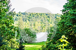 deep dark forest lake with reflections of trees and green foliage