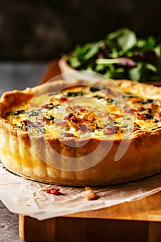 Deep dish quiche Lorraine with crispy bacon and ham, cream, eggs Swiss and Gruyere cheese filling baked in crust. Traditional