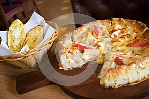 Deep dish seafood pizza Chicago style with cheese garlic bread on the side