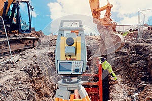 Deep drainage excavation works, with red trench support box installed into the trench and yellow total station