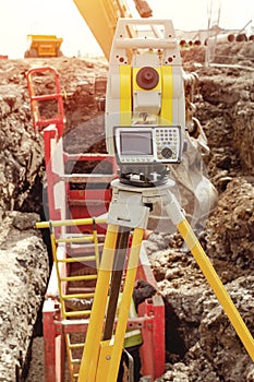 Deep drainage excavation works, with red trench support box installed into the trench and yellow total station next to it