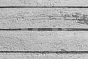 Deep expressive cracks on wooden boards of house wall with old cracked weathered gray paint close up. Abstract pattern as