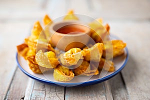 Deep fired Chinese Thai style wonton with minced pork and sweet and sour sauce in ceramic dish