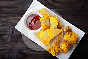 Deep fired Chinese Thai style wonton with minced pork and sweet and sour sauce in ceramic dish