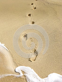 Deep footprints on a blond sandy beach