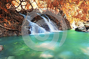 Deep forest waterfall in autumn