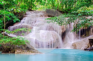 Deep forest waterfall at Erawan waterfall, beautiful waterfall with sunlight rays in deep forest, Erawan National Park