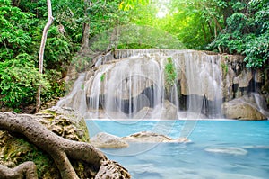 Deep forest waterfall at Erawan waterfall, beautiful waterfall with sunlight rays in deep forest, Erawan National Park