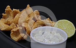 Deep fried anchovies with tartar sauce and lime wedge