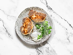 Deep-fried bread crumbs fried halloumi cheese and greek yogurt - a delicious snack, tapas, appetizers on a light marble background