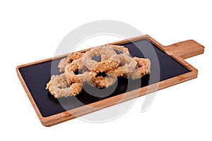Deep fried calamari rings or onion on a wooden board isolated on a white background