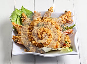 Deep fried cereal prawn served in dish isolated on table top view of singapore food