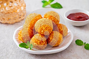 Deep fried cheese balls on plate and ketchup