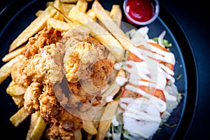 Deep-Fried Chicken chicharr n de pollo , Fried chicken nuggets, French fries and vegetables with chili sauce.