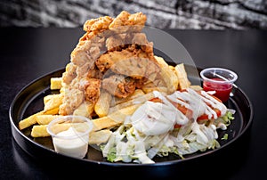 Deep-Fried Chicken chicharr n de pollo , Fried chicken nuggets, French fries and vegetables with chili sauce. photo