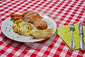 Deep fried chicken escalope or schnitzel with mashed potatoes and pickled cucumbers.