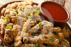 deep fried chicken gizzards in breadcrumbs with chili sauce close-up. horizontal
