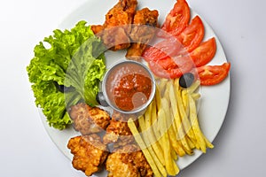 Deep fried chicken platter, chicken wings, nuggets, french fries and fresh green salad with dip tomato sauce