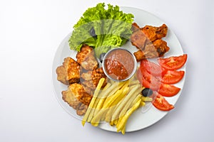 Deep fried chicken platter, chicken wings, nuggets, french fries and fresh green salad with dip tomato sauce